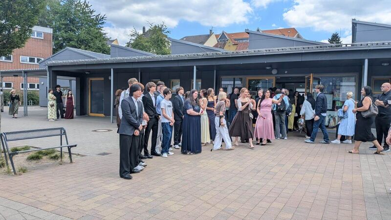 Für ein Gruppenfoto stellen sich die Schülerinnen und Schüler der 10 a im Halbkreis vor der Mensa auf.