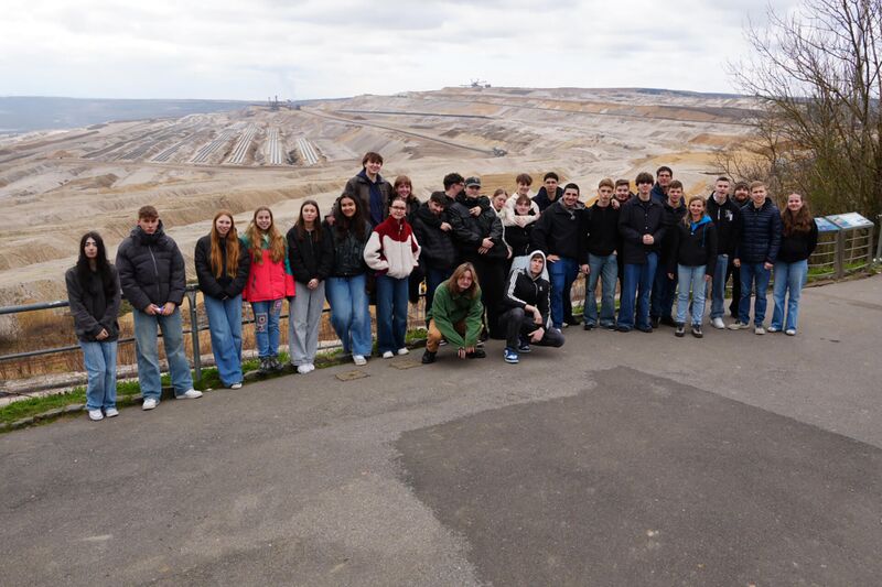 Vor dem Braunkohletagebau Hambach stehen zwei Erkundekurse und machen ein Gruppenbild Exkursion der EK Kurse zum Braunkohletagebau Hambach