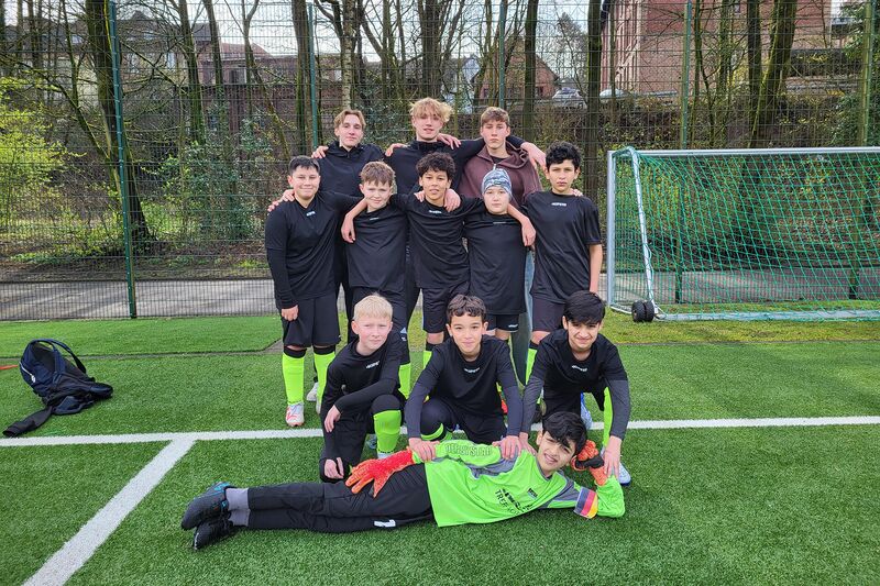 Auf einem Kunstrasen posiert eine Fußballmannschaft mit 12 Jungs Schulmannschaft bei der Stadtmeisterschaften Fußball WK 4