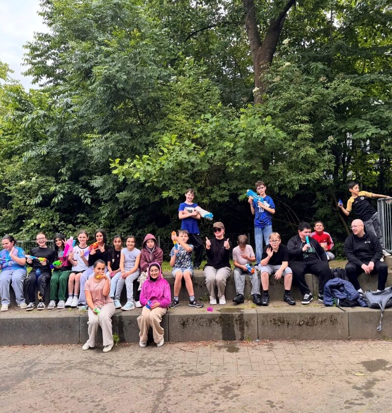 Nach der Wasserschlacht ruht sich die Klasse 5a auf den Sitzgelegenheiten auf dem kleinen Schulhof aus.